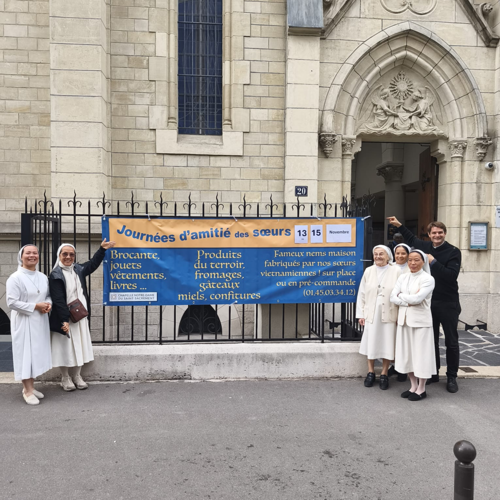 Les sœurs et le prêtre devant la chapelle, autour de la banderole des Journées d'amitié du 13 au 15 novembre